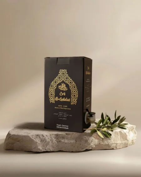 Oro Al Andalus Bib Queen 2L bag-in-box Extra Virgin Olive Oil in a black and gold Andalusian arch design box, displayed on a travertine stone with a fresh olive branch