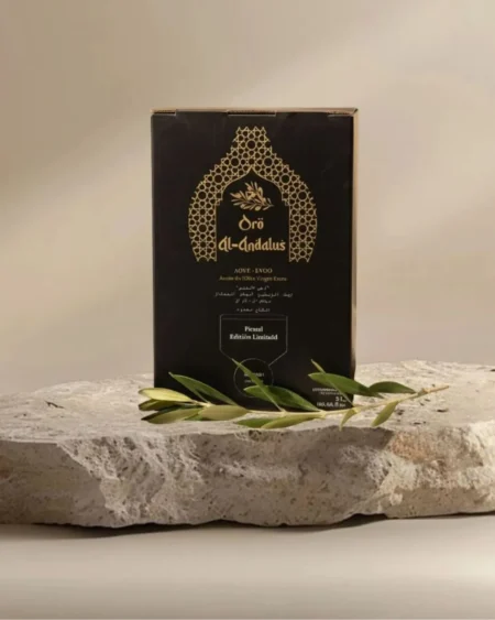 Oro Al Andalus Bib Queen 5L bag-in-box Extra Virgin Olive Oil in a black and gold Andalusian arch design box, displayed on a travertine stone with a fresh olive branch